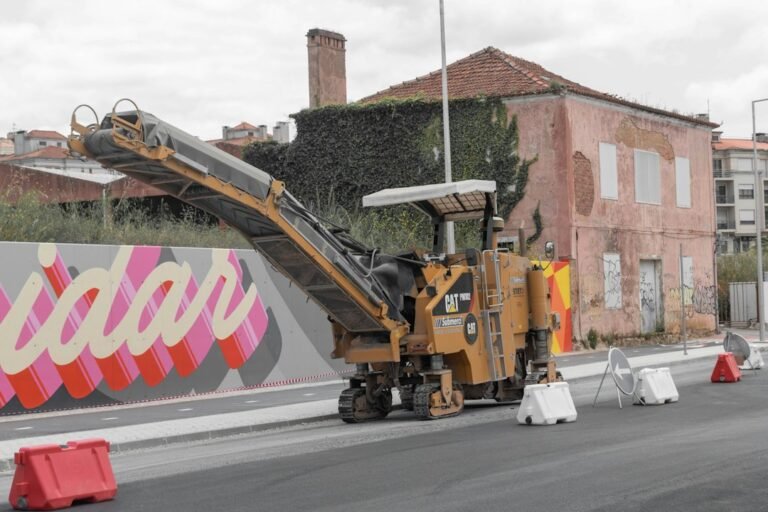 A yellow road milling machine on a newly paved street